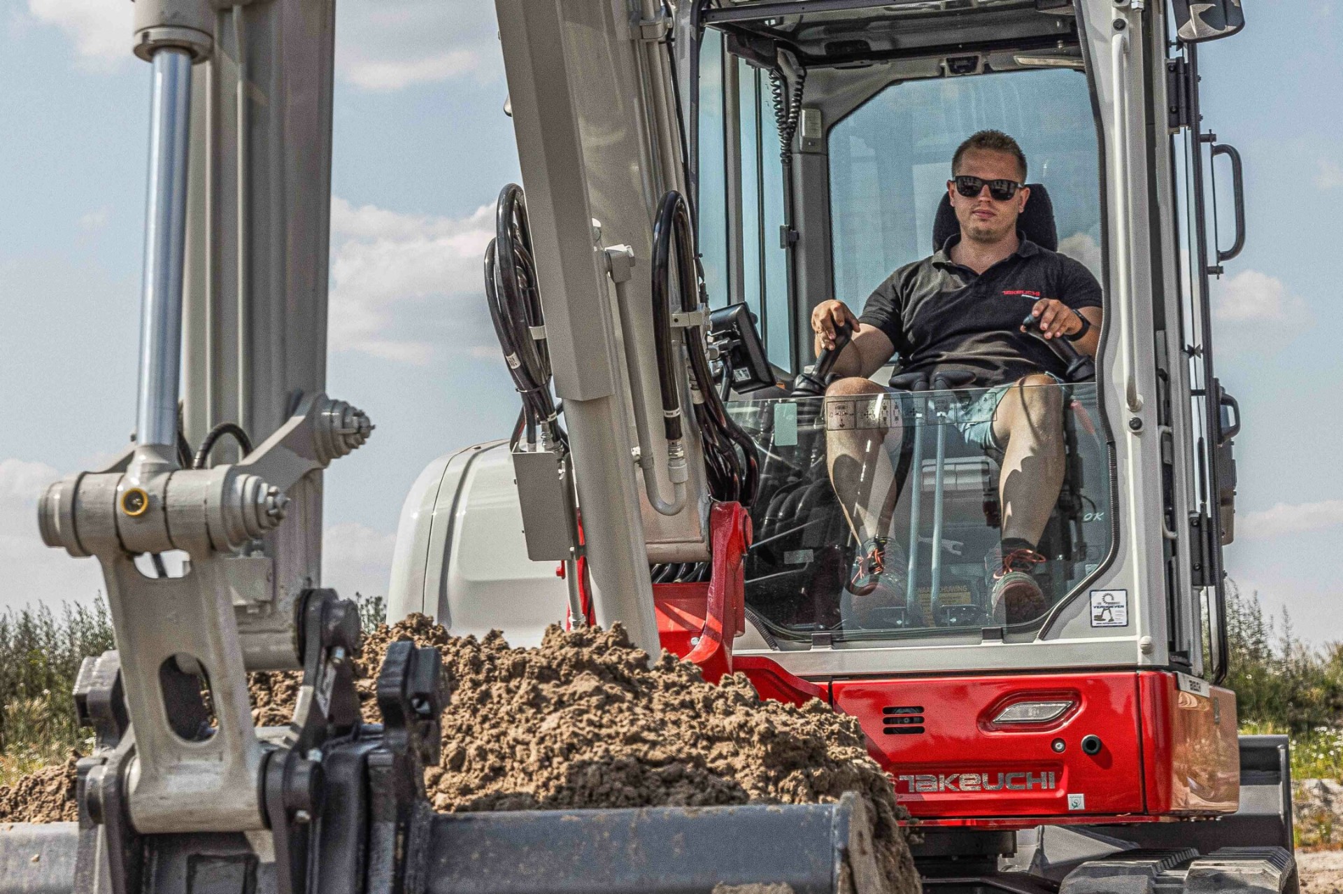 Ervaren kraanman operator aan het werk in Takeuchi minigraver